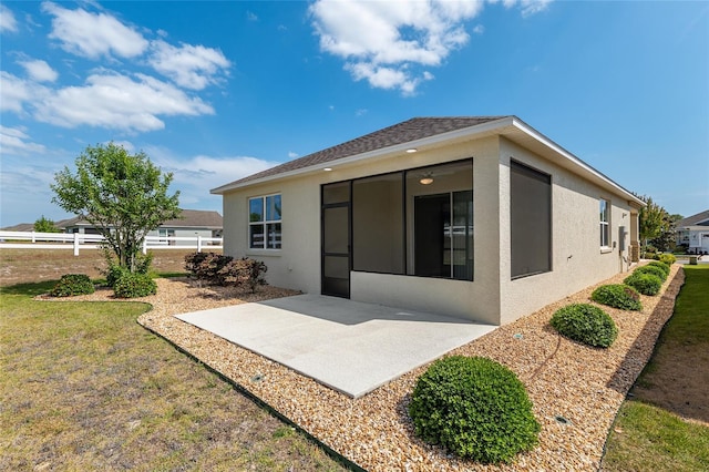 9923 SW 98th Ln, Ocala, FL 34481 - back of property with stucco siding, a patio area, a yard, and a sunroom