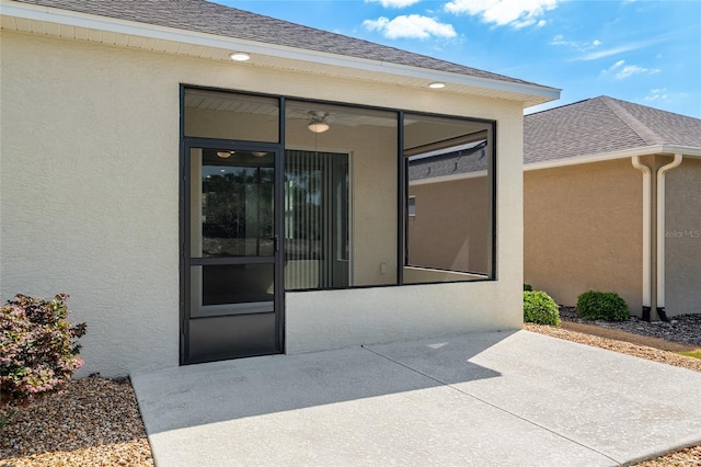 9923 SW 98th Ln, Ocala, FL 34481 - doorway to property featuring stucco siding, roof with shingles, and a patio