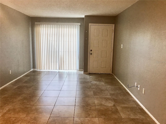 5440 SE 30th Pl, Ocala, FL 34480 - unfurnished room featuring baseboards, a textured wall, a textured ceiling, and a wealth of natural light
