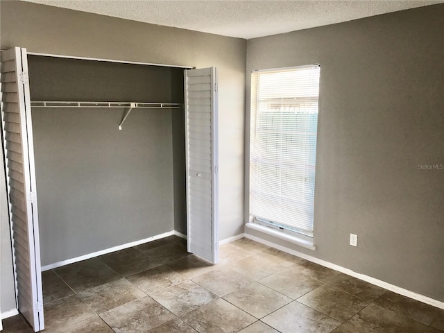 5440 SE 30th Pl, Ocala, FL 34480 - unfurnished bedroom featuring a closet, a textured ceiling, and baseboards