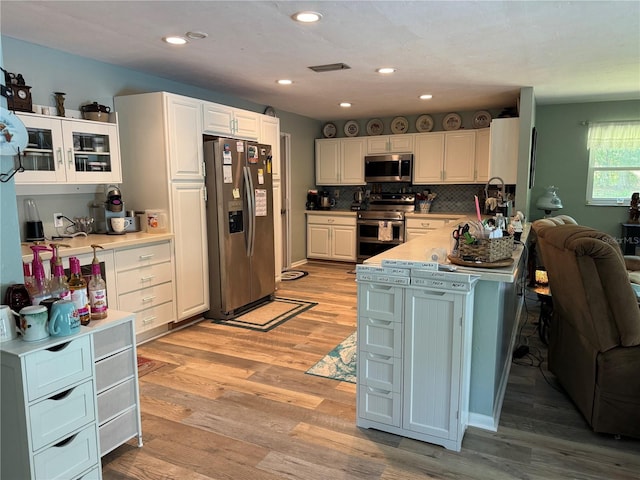 8951 SW 202nd Avenue Rd, Dunnellon, FL 34431 - kitchen with stainless steel appliances, light wood-style flooring, light countertops, decorative backsplash, and recessed lighting