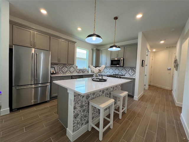 5785 SW 87th Court Rd, Ocala, FL 34481 - kitchen featuring stainless steel appliances, wood finish floors, gray cabinets, tasteful backsplash, and recessed lighting