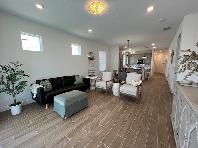 5785 SW 87th Court Rd, Ocala, FL 34481 - living room with a chandelier, light wood-style floors, baseboards, and recessed lighting