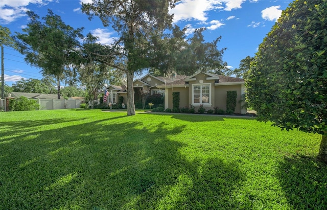 811 SE 49th Ave, Ocala, FL 34471 - view of front of home featuring a front lawn, stucco siding, and fence