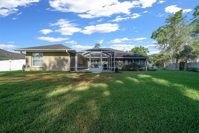 811 SE 49th Ave, Ocala, FL 34471 - back of house featuring a fenced backyard, glass enclosure, stucco siding, and a yard