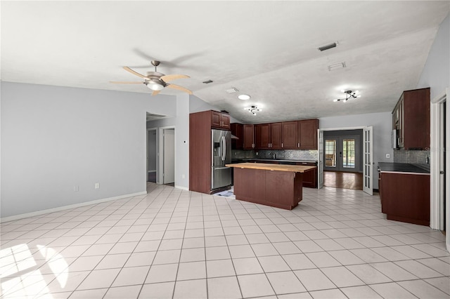 14171 SW 8th Ave, Ocala, FL 34473 - kitchen with stainless steel fridge, lofted ceiling, backsplash, a kitchen island, and open floor plan