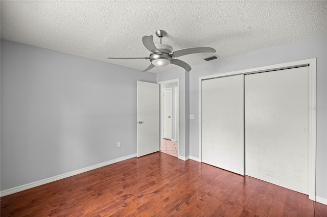 14171 SW 8th Ave, Ocala, FL 34473 - unfurnished bedroom with wood finished floors, a closet, a textured ceiling, and ceiling fan