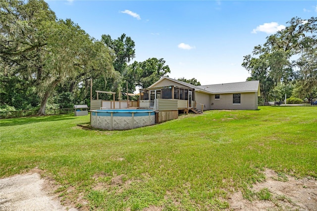 14171 SW 8th Ave, Ocala, FL 34473 - rear view of property featuring a sunroom, an outdoor pool, and view of wooded area