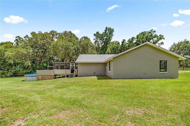 14171 SW 8th Ave, Ocala, FL 34473 - rear view of property with a sunroom, an outdoor pool, a lawn, and stucco siding