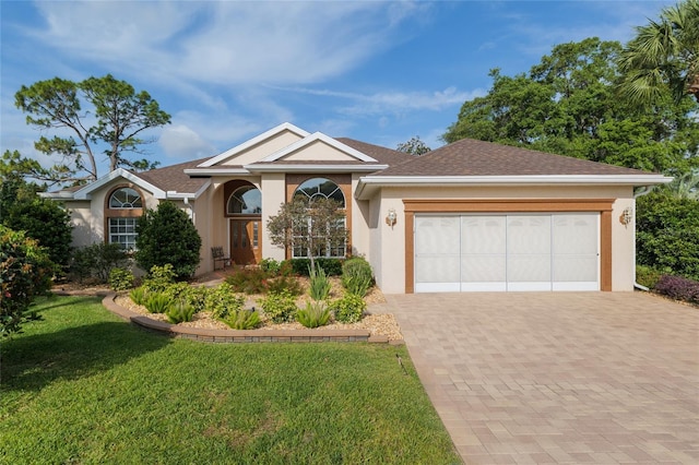 ranch-style home with stucco siding, decorative driveway, a front lawn, and a garage