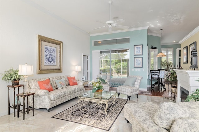 living area featuring ornamental molding, a ceiling fan, and baseboards