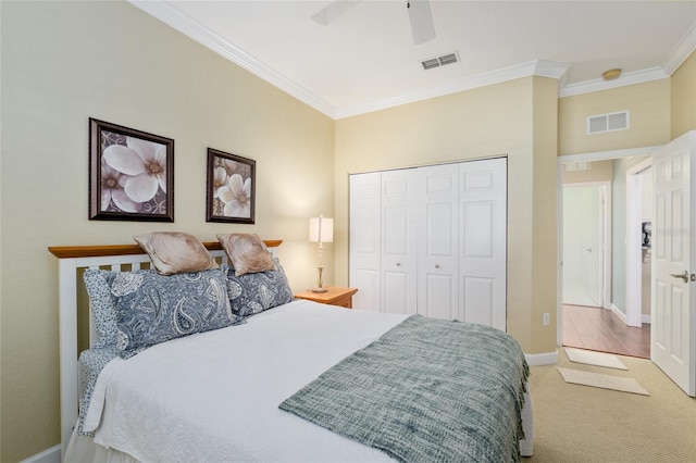 bedroom with visible vents, a closet, ornamental molding, and carpet floors