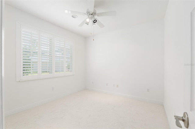carpeted empty room with ceiling fan and baseboards