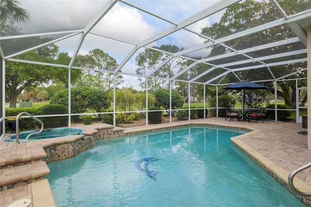 outdoor pool with a patio, glass enclosure, and an in ground hot tub