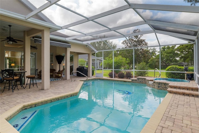 outdoor pool with a patio, ceiling fan, an in ground hot tub, and glass enclosure