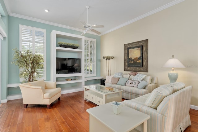 living area featuring ornamental molding, ceiling fan, wood finished floors, and plenty of natural light