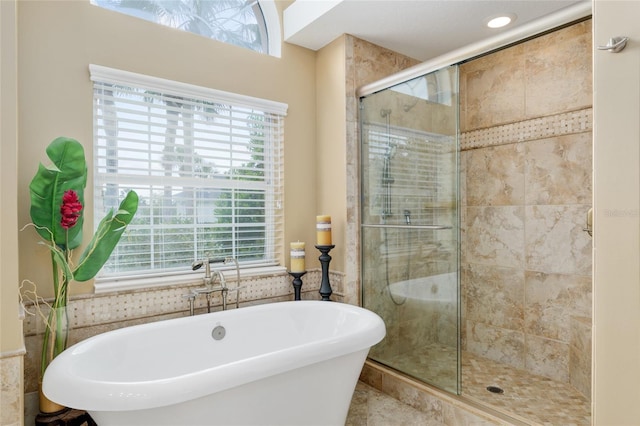 full bath with a shower stall, plenty of natural light, and a soaking tub