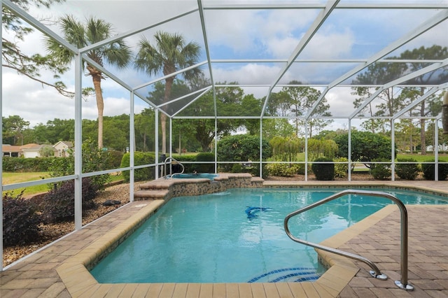 pool with a patio area and an in ground hot tub