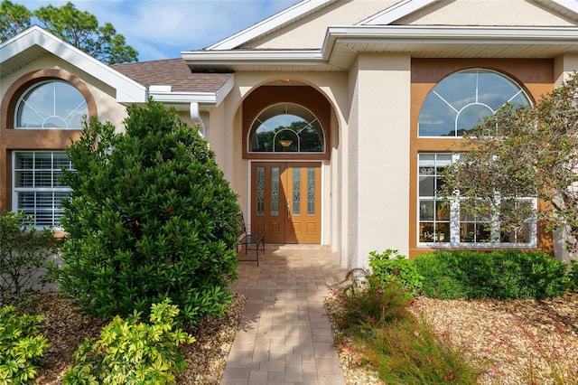 view of exterior entry featuring stucco siding