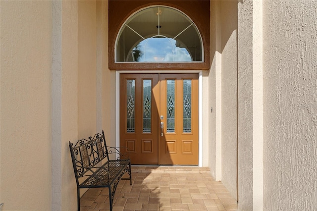 property entrance featuring stucco siding and french doors