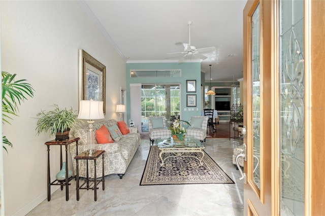 living area with ornamental molding and a ceiling fan