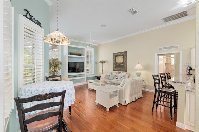 living area featuring visible vents and crown molding