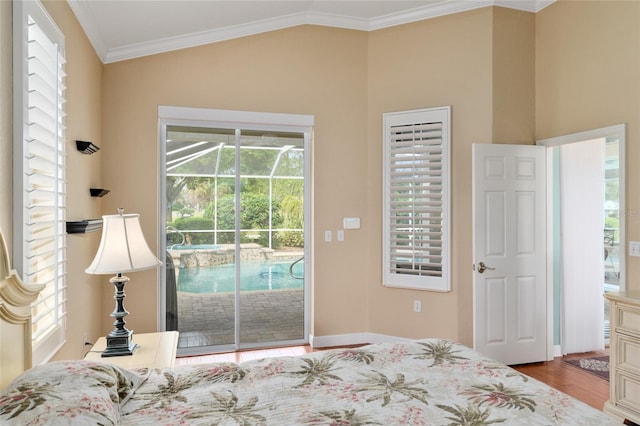 bedroom featuring access to exterior, wood finished floors, multiple windows, and ornamental molding
