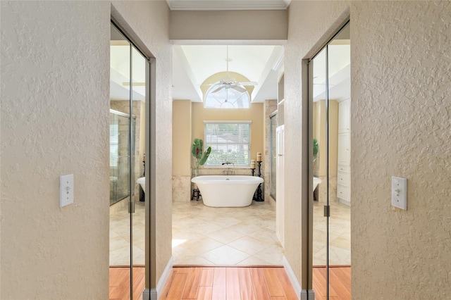 hallway featuring wood finished floors and a textured wall