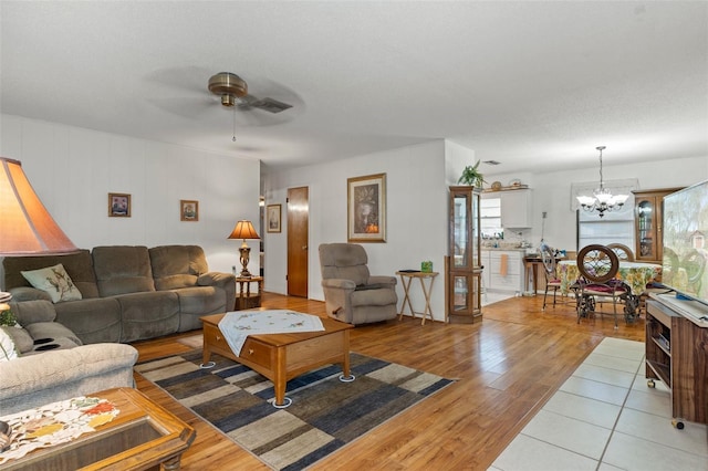 1366 N Merlin Ter, Crystal River, FL 34429 - living area featuring visible vents, light wood-type flooring, and ceiling fan with notable chandelier