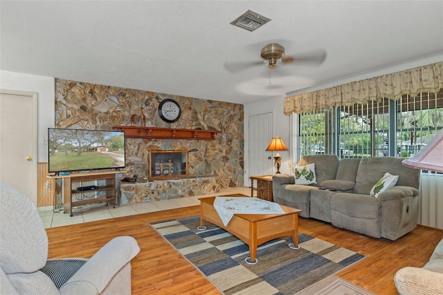 1366 N Merlin Ter, Crystal River, FL 34429 - living area featuring radiator, a ceiling fan, visible vents, a stone fireplace, and wood finished floors