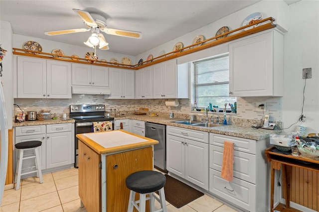 1366 N Merlin Ter, Crystal River, FL 34429 - kitchen with light tile patterned floors, appliances with stainless steel finishes, under cabinet range hood, a kitchen island, and a sink