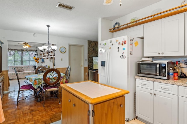 1366 N Merlin Ter, Crystal River, FL 34429 - kitchen with stainless steel microwave, white fridge with ice dispenser, visible vents, and white cabinetry