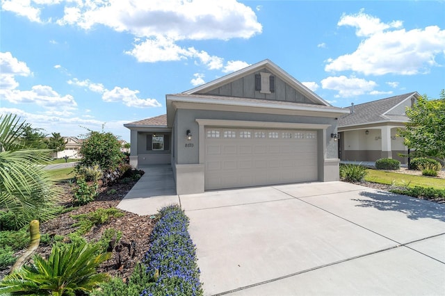 view of front facade featuring concrete driveway, an attached garage, stucco siding, and board and batten siding
