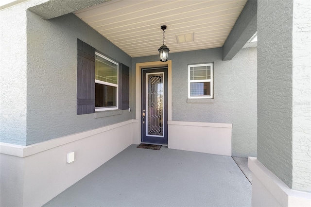 entrance to property featuring stucco siding