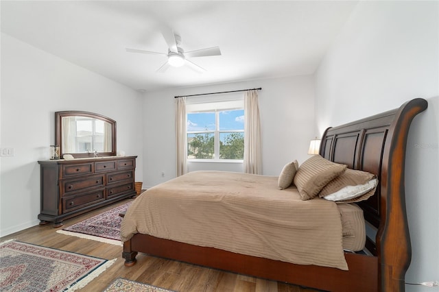 bedroom featuring wood finished floors, a ceiling fan, and baseboards