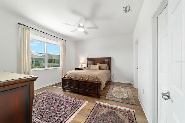 bedroom with light wood-style flooring, baseboards, and ceiling fan