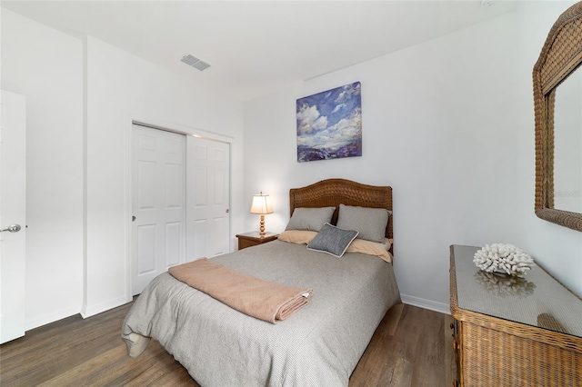 bedroom featuring wood finished floors, a closet, and baseboards