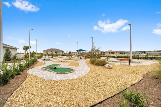 surrounding community with an area to practice putting and a residential view