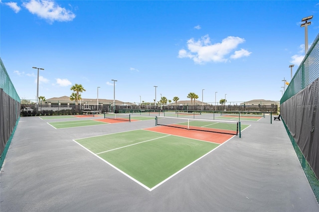 view of tennis court featuring fence and community basketball court