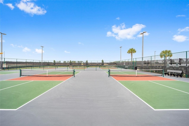 view of tennis court with community basketball court and fence