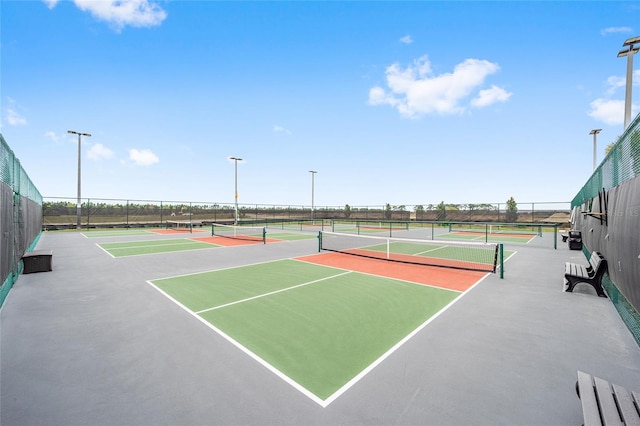 view of tennis court with community basketball court and fence