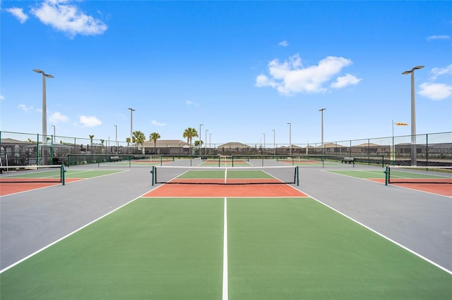 view of tennis court with community basketball court and fence