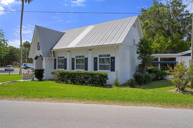 view of property exterior with concrete block siding, fence, a yard, and metal roof