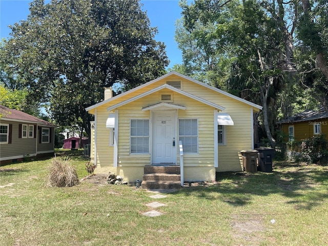 621 NE 20th St, Ocala, FL 34470 - view of front of property with a front lawn, a chimney, and entry steps