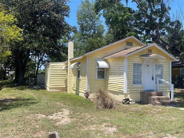 621 NE 20th St, Ocala, FL 34470 - view of front facade featuring a front yard and a chimney