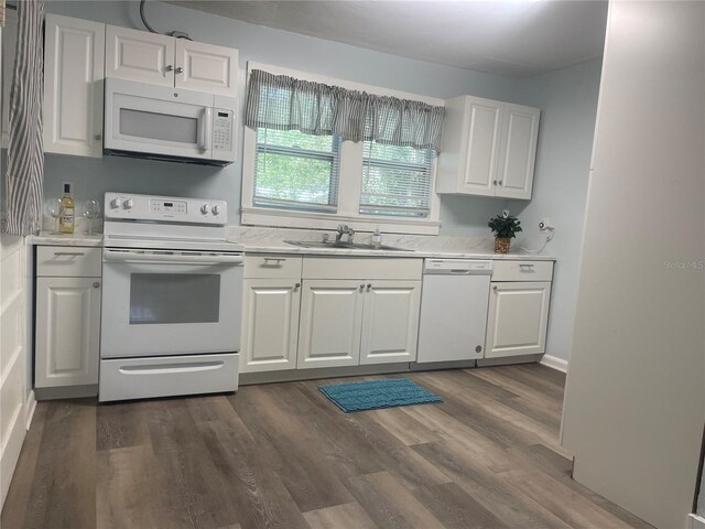 621 NE 20th St, Ocala, FL 34470 - kitchen featuring white appliances, a sink, light countertops, white cabinets, and dark wood finished floors