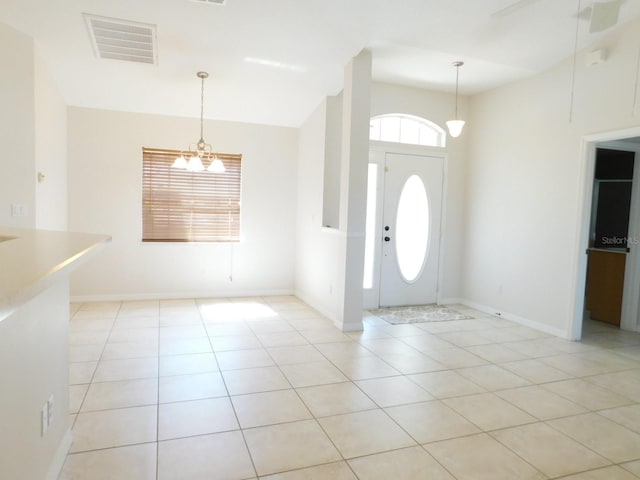 entrance foyer featuring light tile patterned flooring, visible vents, a chandelier, and baseboards