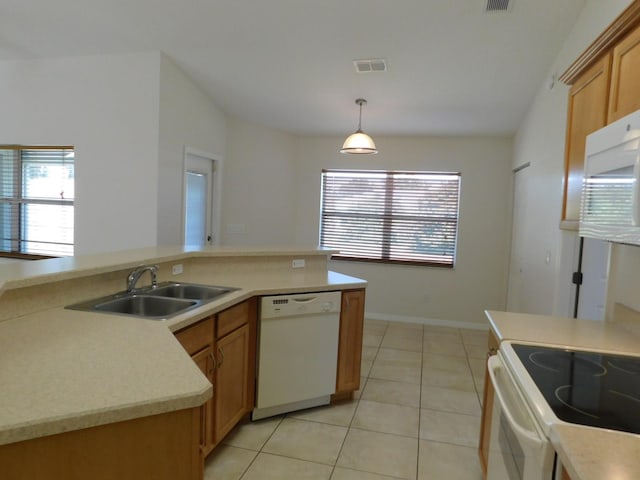 kitchen with a sink, light tile patterned flooring, white appliances, light countertops, and hanging light fixtures