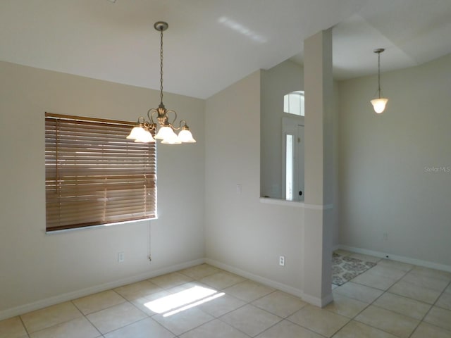 tiled spare room featuring a chandelier and baseboards