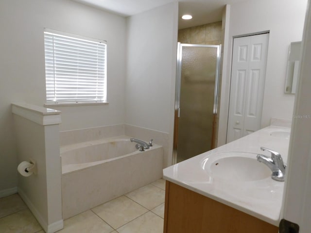 bathroom with a sink, double vanity, a stall shower, tile patterned floors, and a garden tub